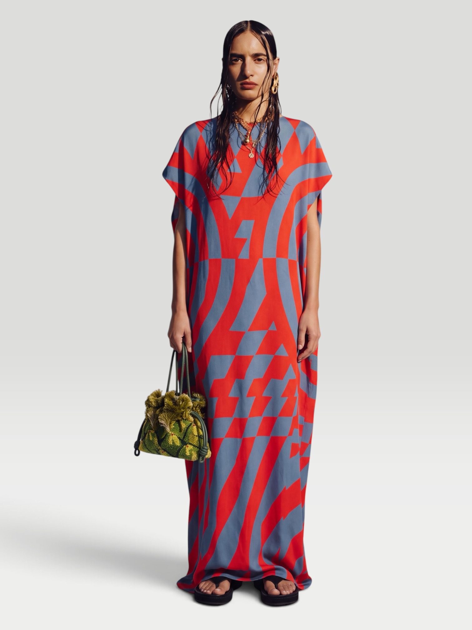 Dries Van Noten Printed Satin Maxi Dress in red, worn with Loewe Paula's Ibiza Flamenco Mini Beaded Clutch, Phoebe Philo Frizz Flip Flop, Phoebe Philo Peak Sunglasses, Love Adorned Vintage Diamond Corner Signet Ring, walking the city. Styled by Sharon Lombardo for FDV Concierge.