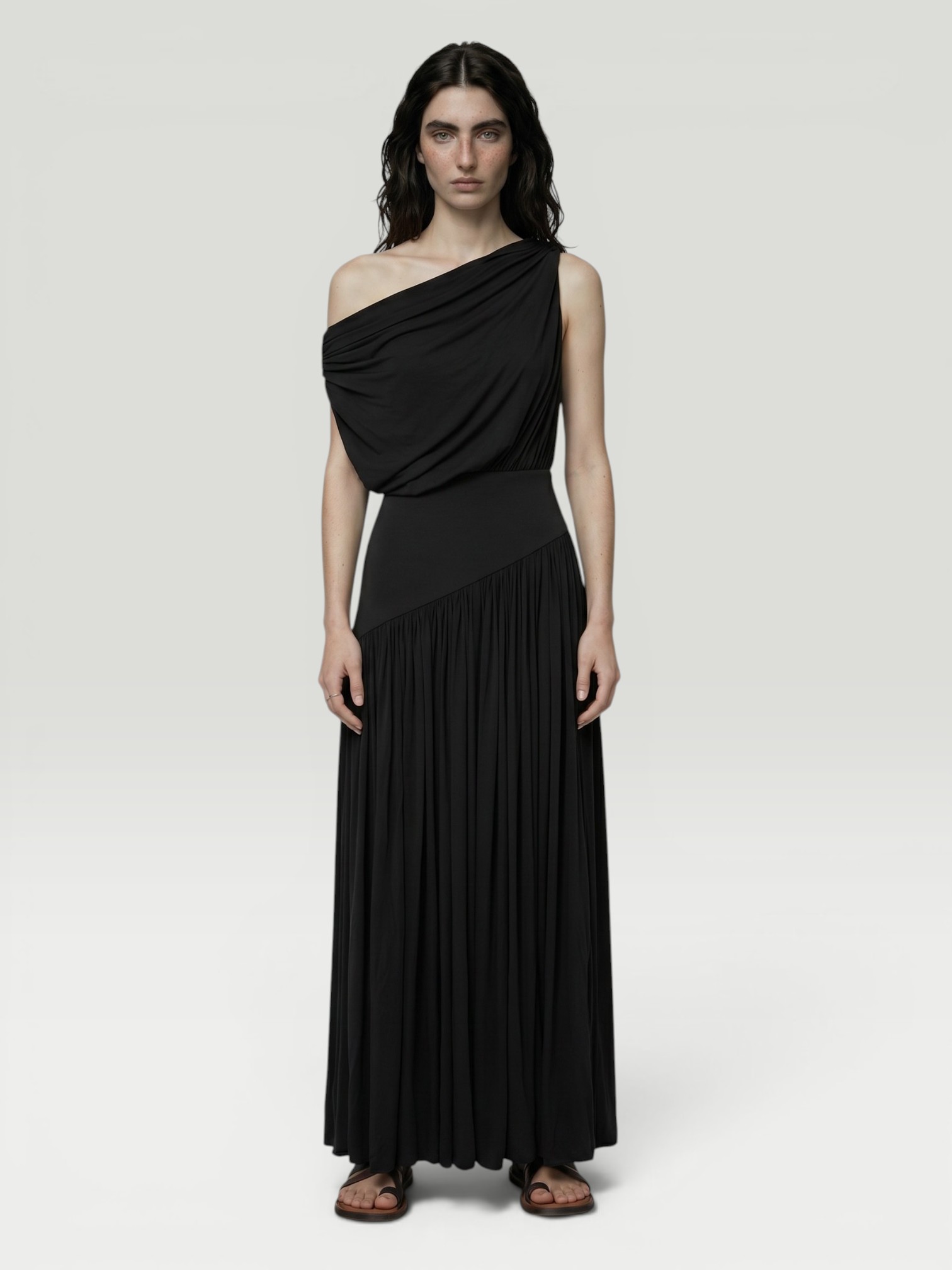 Abadia Gwen One-Shoulder Maxi Dress in black, worn with Bottega Veneta Sampieri Flat Thong. Styled by Sharon Lombardo for FDV Concierge.