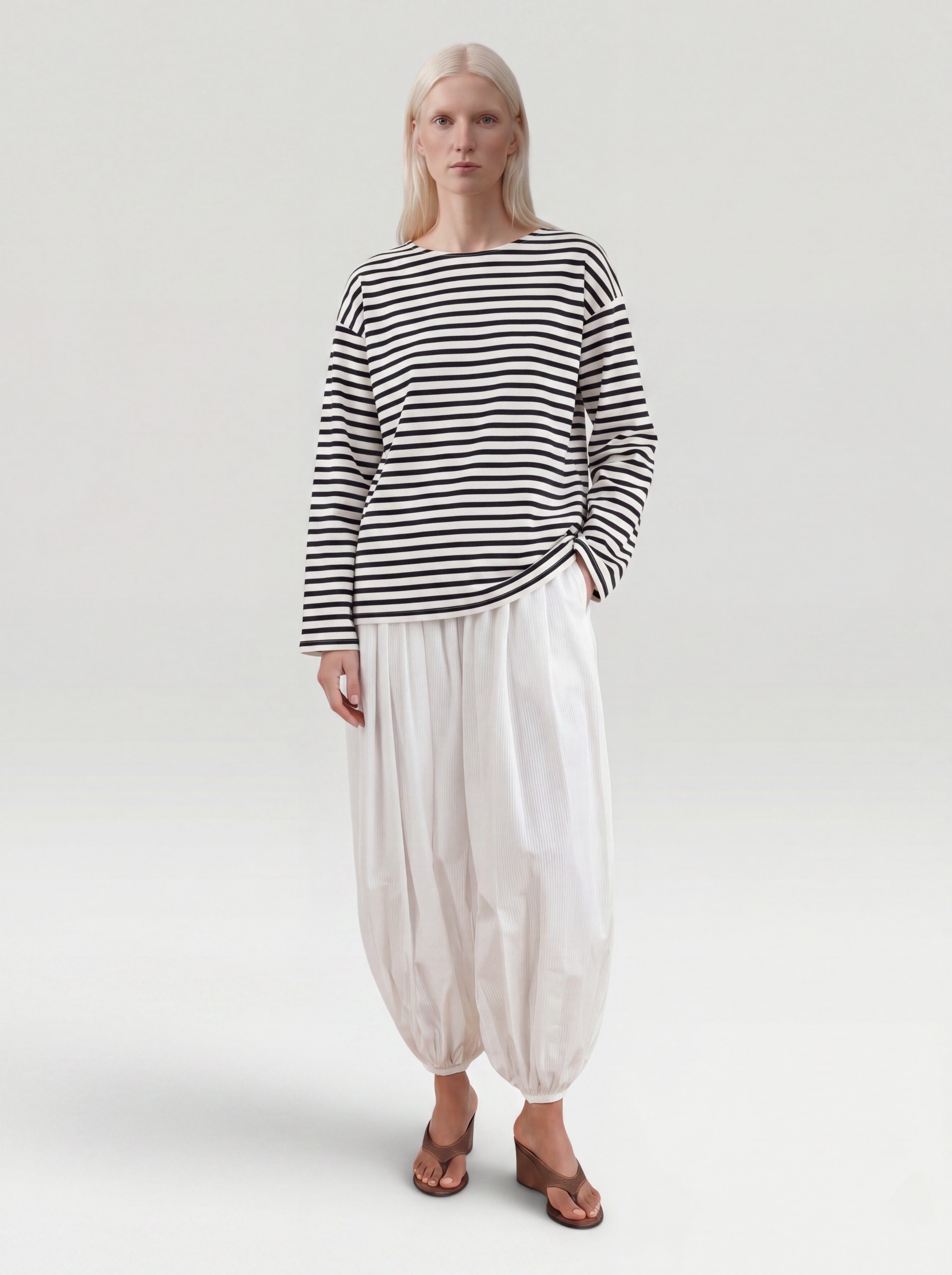 Alaïa Balloon Pants in white, worn with Alaïa Cropped Jersey Turtleneck Tee, Alaïa Wedge Thong Mule. Styled by Sharon Lombardo for FDV Concierge.