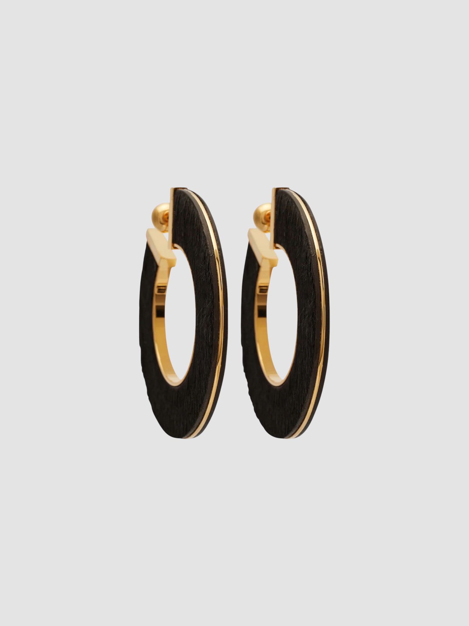 Alaïa Blade Medium Leather Hoop Earrings in brown.