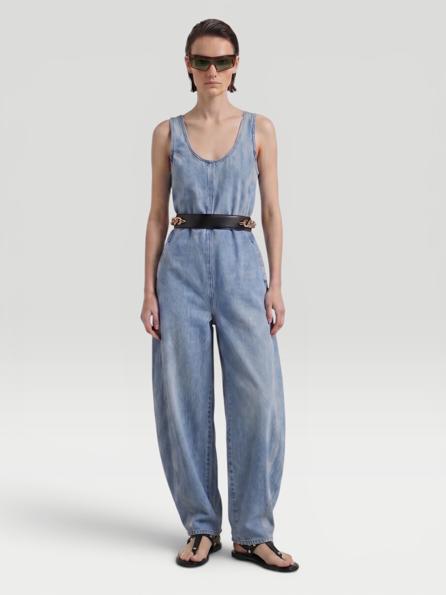 Alaïa Denim Jumpsuit in indigo, worn with Alaïa Torsion Leather Belt, Phoebe Philo Cruise Sunglasses, CO Ankle Wrap Sandal. Styled by Sharon Lombardo for FDV Concierge.