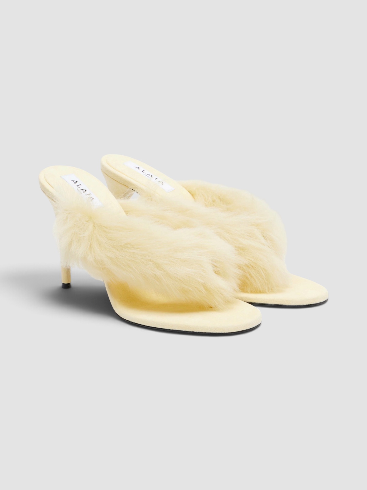 Alaïa Shearling and Leather Thong Sandals in yellow.