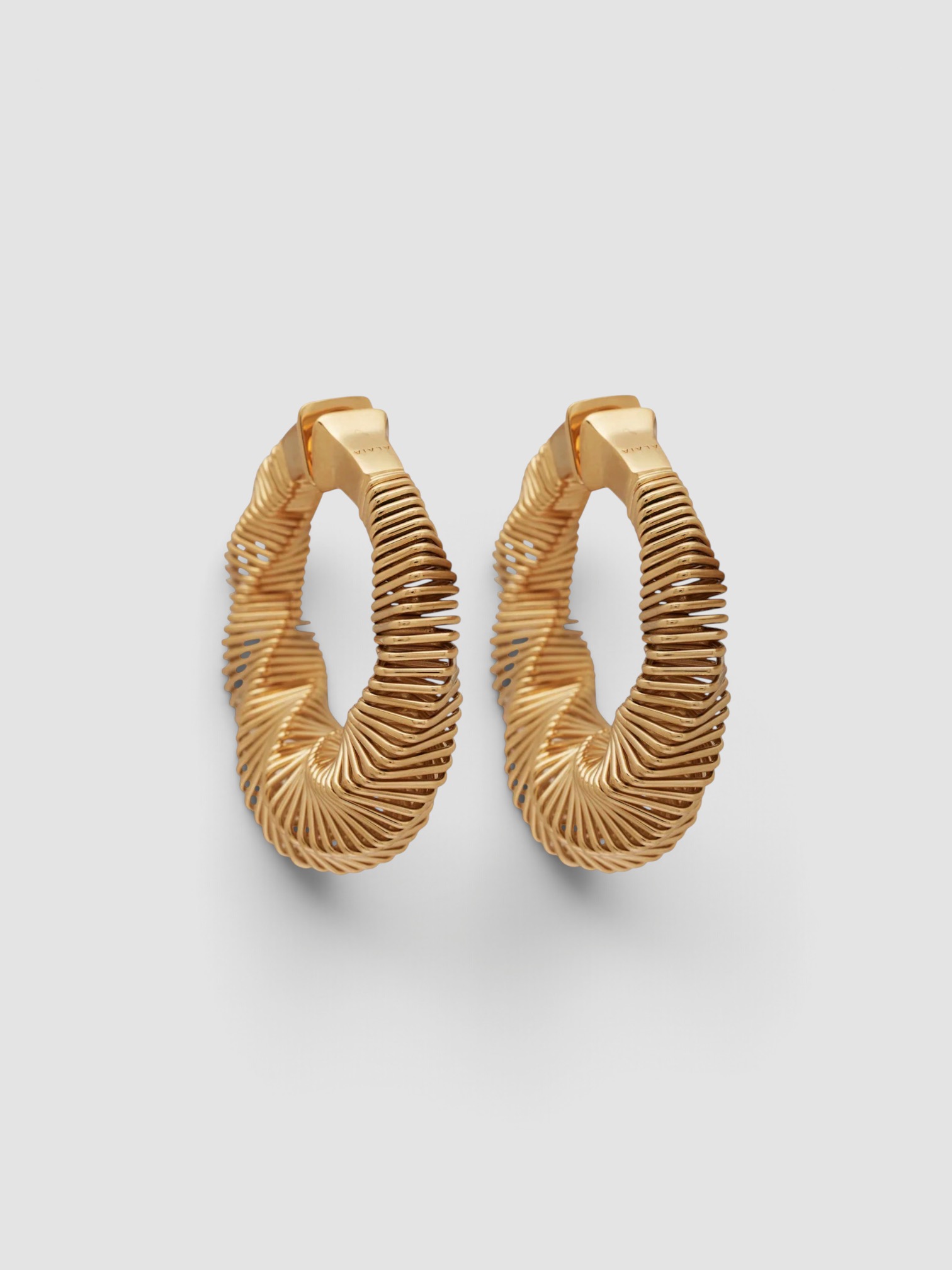 Alaïa Spiral Small Hoop Earrings in gold, worn with Saint Laurent Cargo Jumpsuit, Phoebe Philo Leather Belt, CO Ankle Wrap Sandal. Styled by Sharon Lombardo for FDV Concierge.
