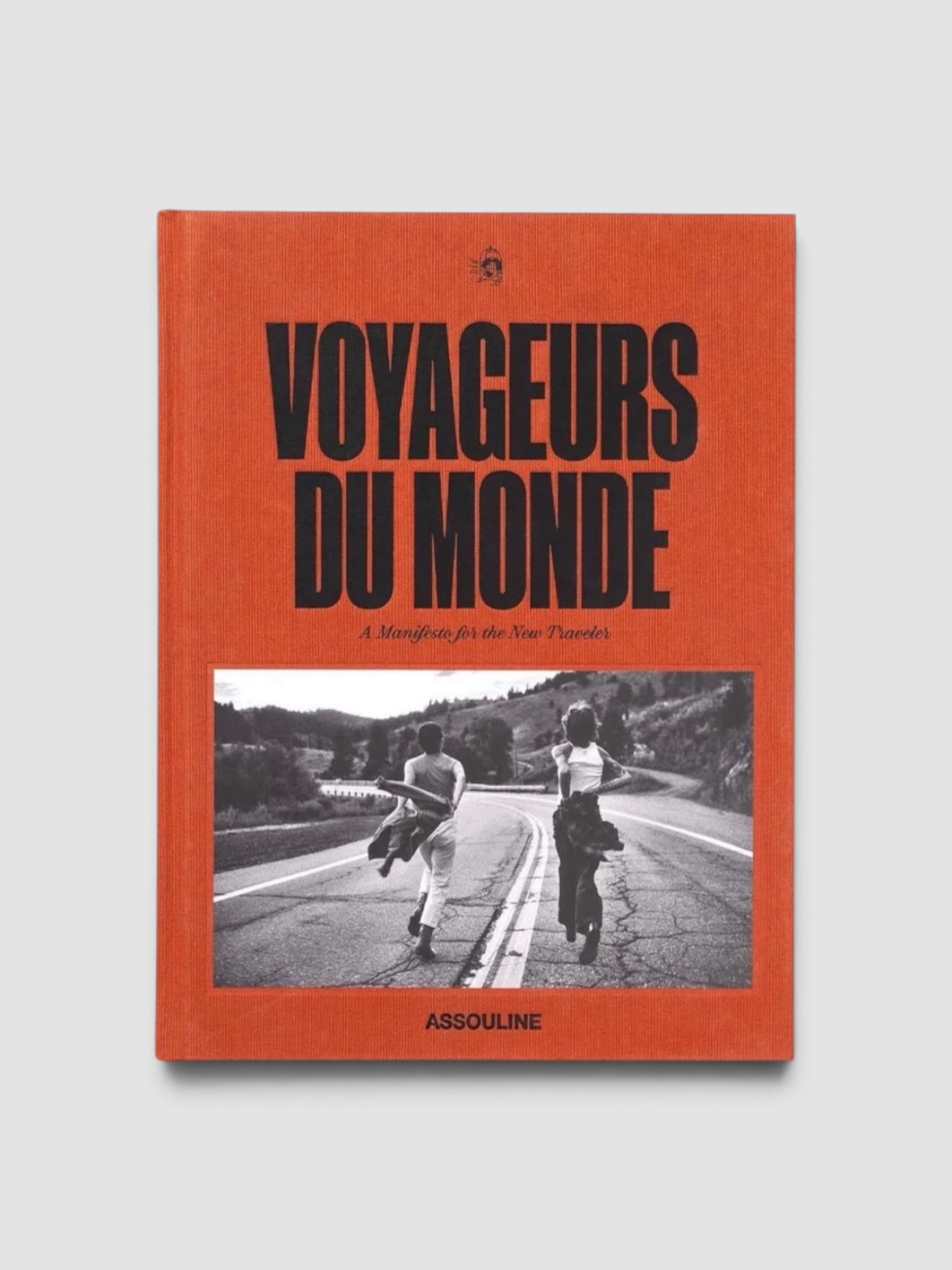 Assouline Voyageurs du Monde: A Manifesto for the New Traveler in orange.