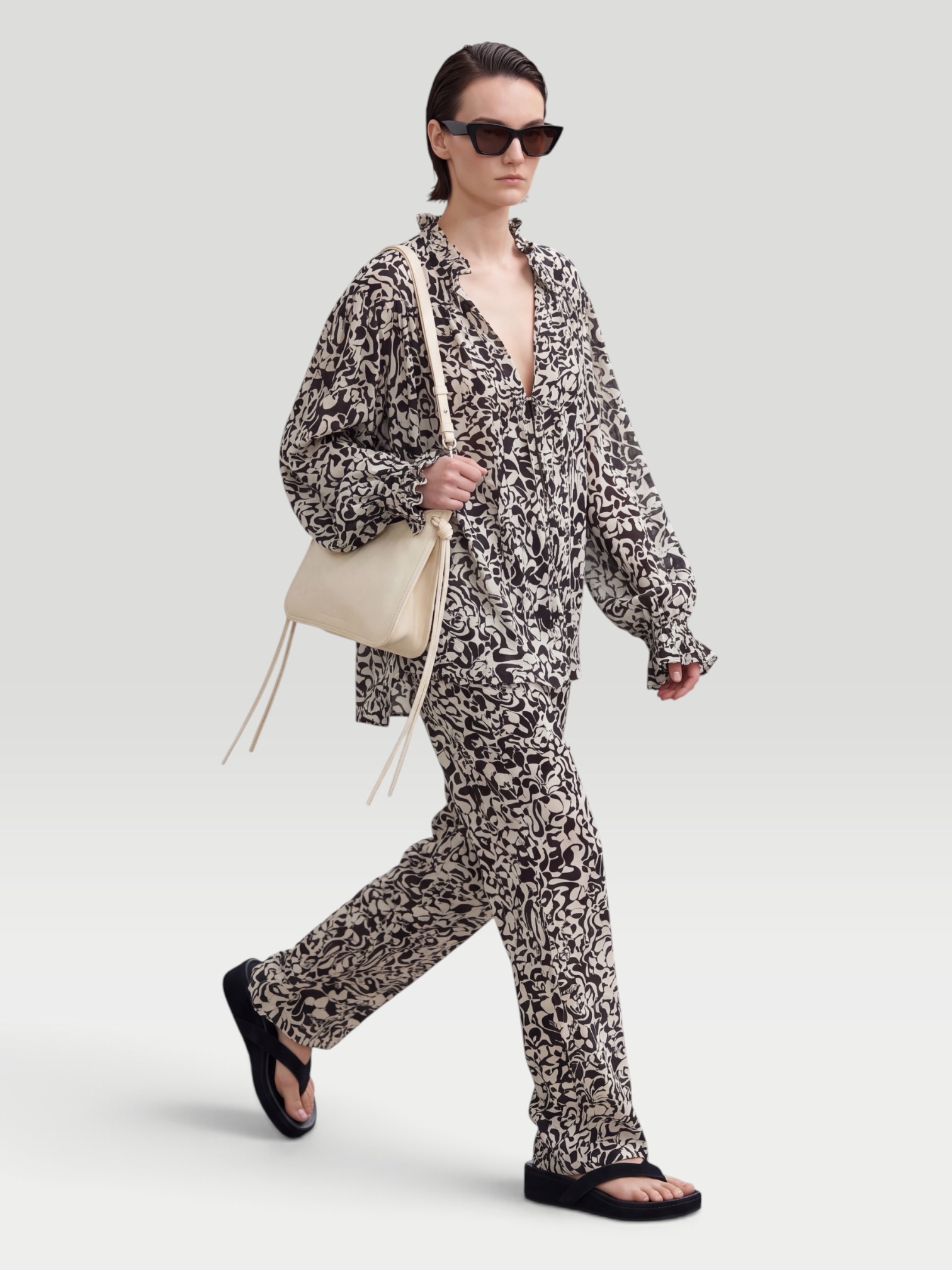 Dries Van Noten Printed Straight Pants in black/cream, worn with Dries Van Noten Printed Blouse, Phoebe Philo Frizz Flip Flop, Phoebe Philo Small Gig Leather Shoulder Bag, Phoebe Philo Peak Sunglasses, walking the city. Styled by Sharon Lombardo for FDV Concierge.