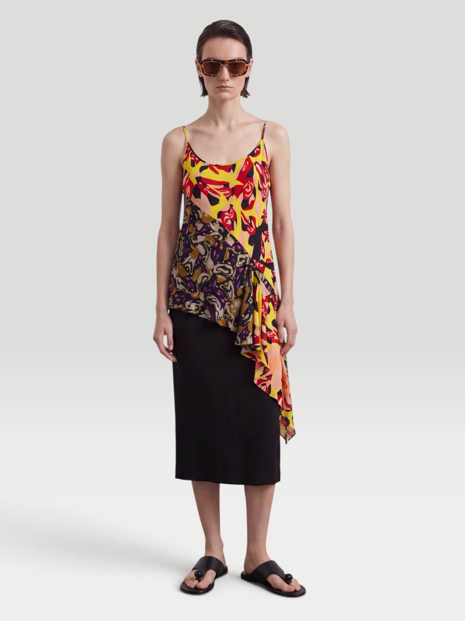 Dries Van Noten Ruffled Printed Asymmetric Georgette Camisole in yellow, worn with Dries Van Noten Printed Wide-Leg Pants, Dries Van Noten Flat Sandal, Dries Van Noten Marche Medium Fringed Top-Handle Bag, ALAÏA Mask-Frame Acetate Sunglasses, the day. Styled by Sharon Lombardo for FDV Concierge.