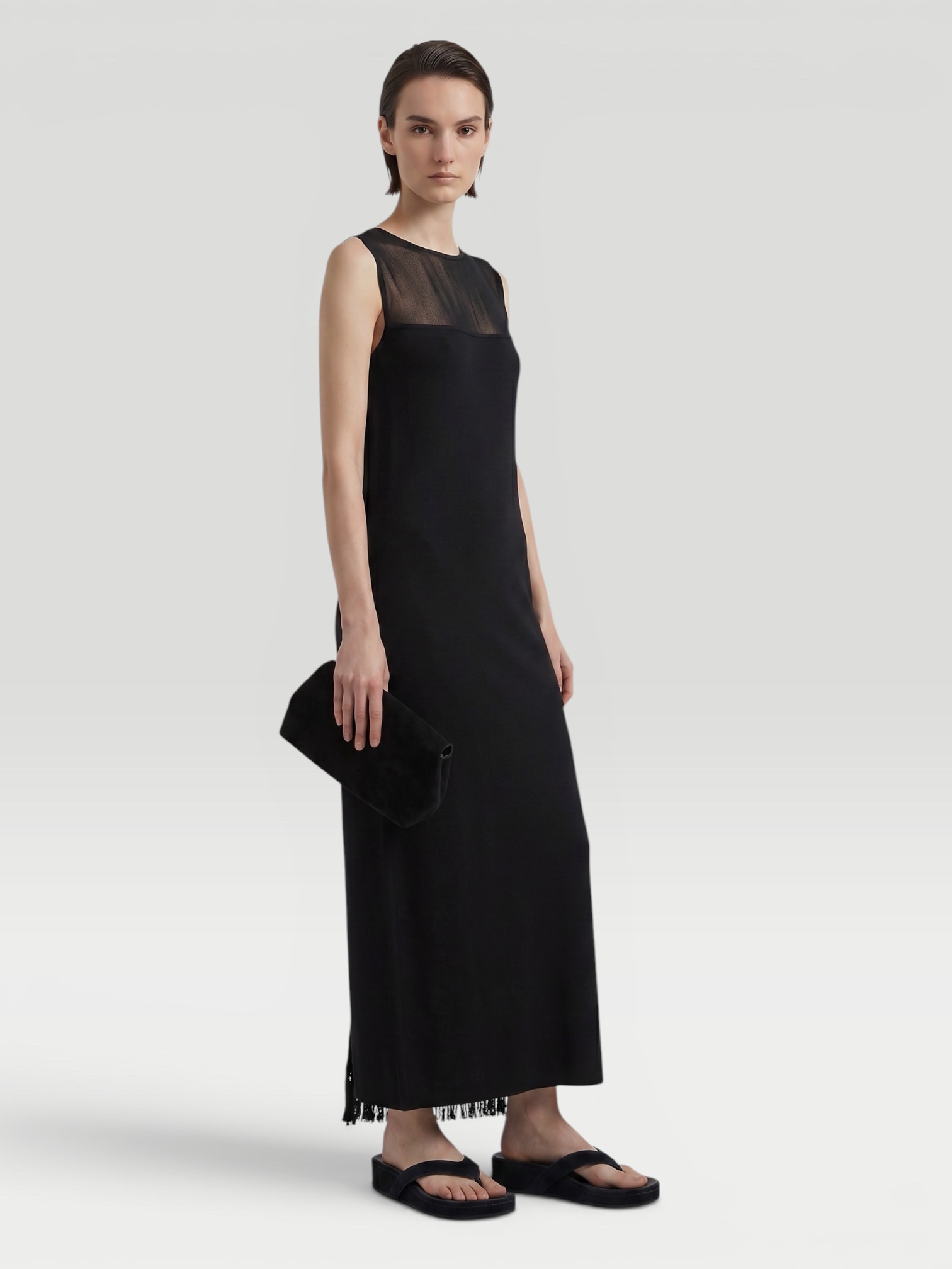 KHAITE Ruslan Fringed Knit Maxi Dress in black, worn with Bottega Veneta Salsa Thong. Styled by Sharon Lombardo for FDV Concierge.