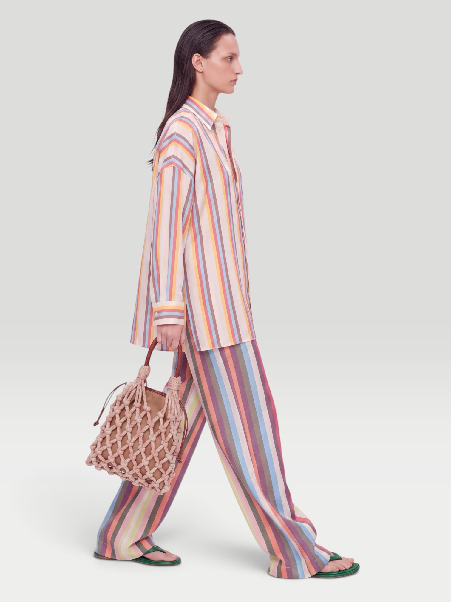 Marrakshi Life The Oversized Striped Cotton-Poplin Shirt in cream stripe, worn with Marrakshi Life The Palazzo Striped Cotton Wide-Leg Pants, Bottega Veneta Sampieri Flat Thong, Prada Noué Medium Cotton Macramé Bag, Dries Van Noten Oval Sunglasses, on the water. Styled by Sharon Lombardo for FDV Concierge.