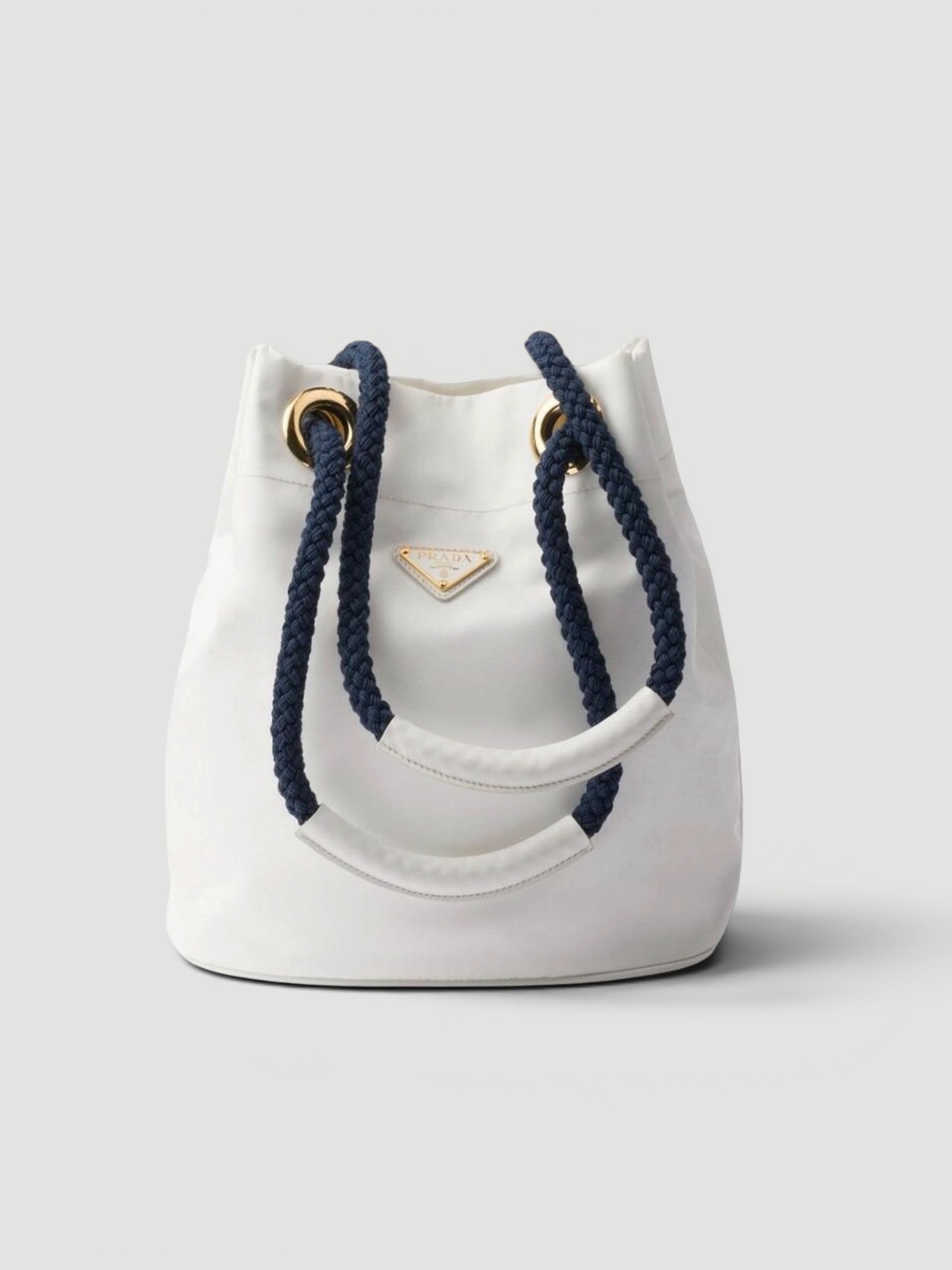 Prada Mariner Re-Nylon Small Bucket Bag in white, worn with Totême Striped Shirtdress. Styled by Sharon Lombardo for FDV Concierge.
