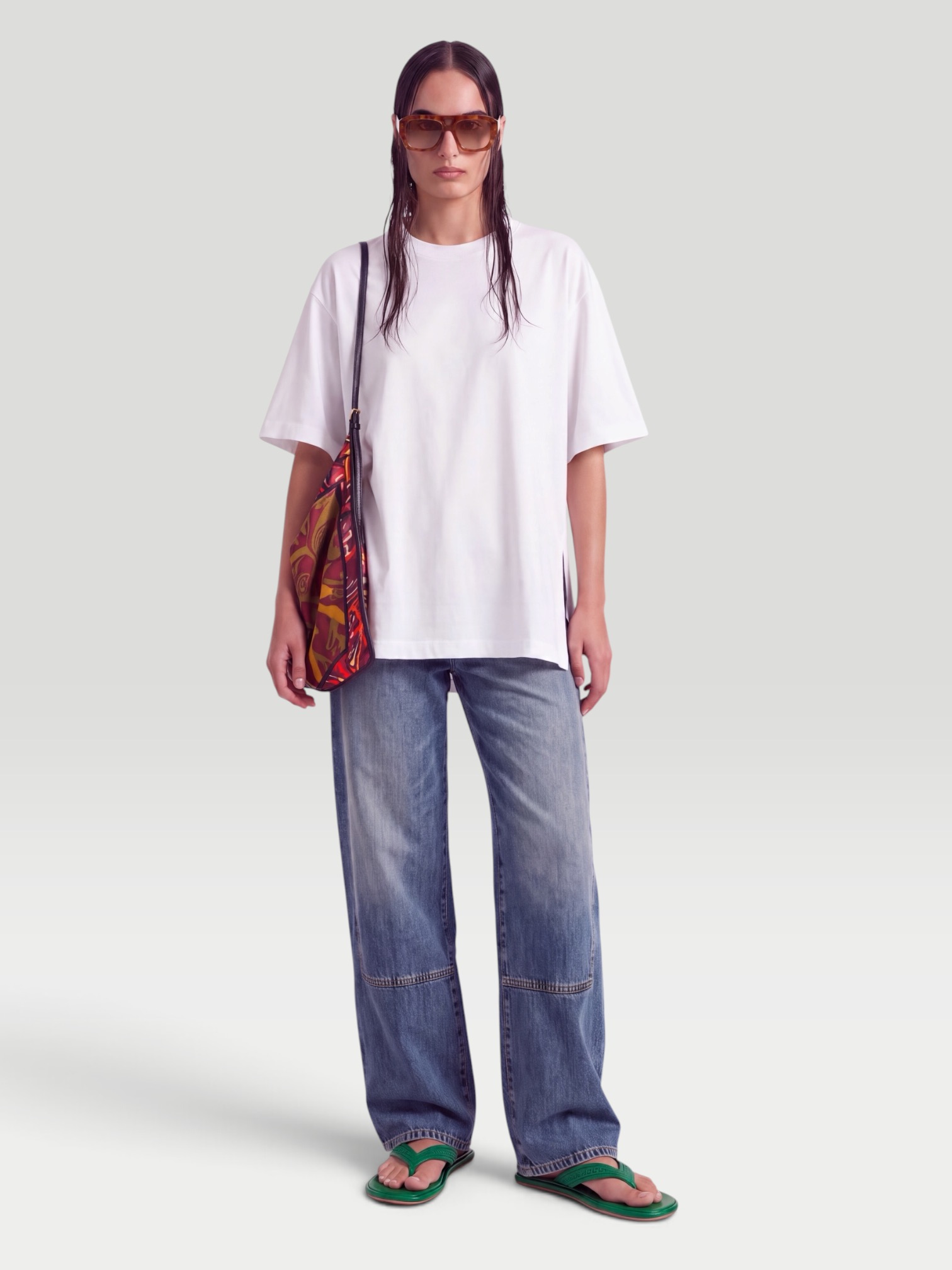 RÙADH The Holt Oversized Organic Cotton-Jersey T-Shirt in white, worn with aligrace Marlow Jean, Bottega Veneta Sampieri Flat Thong, Dries Van Noten Bead-Embellished Printed Leather-Trimmed Velvet Shoulder Bag, Miu Miu Hexagon-Frame Gold-Tone Sunglasses, the evening. Styled by Sharon Lombardo for FDV Concierge.