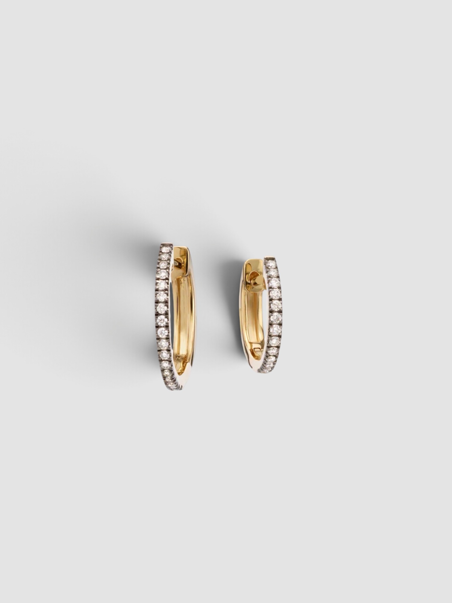 Stone and Strand Come Closer Huggie Earrings in gold.