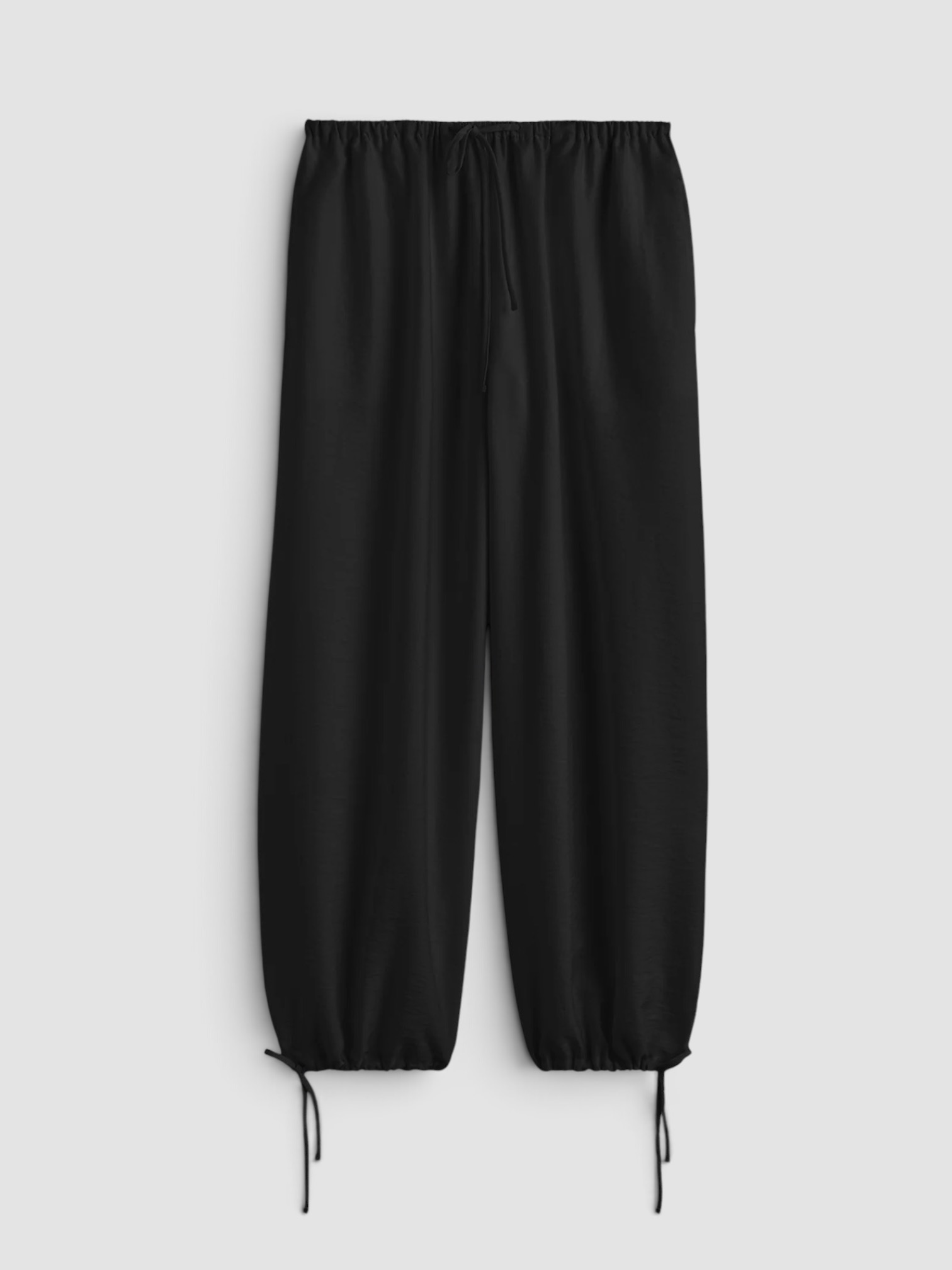 Toteme Lyocell-Blend Tapered Pants in black, worn with Róhe Off Shoulder Lapel Top, Bottega Veneta Salsa Thong, Phoebe Philo Gig Leather Shoulder Bag, Phoebe Philo Bombe Sunglasses, the evening. Styled by Sharon Lombardo for FDV Concierge.