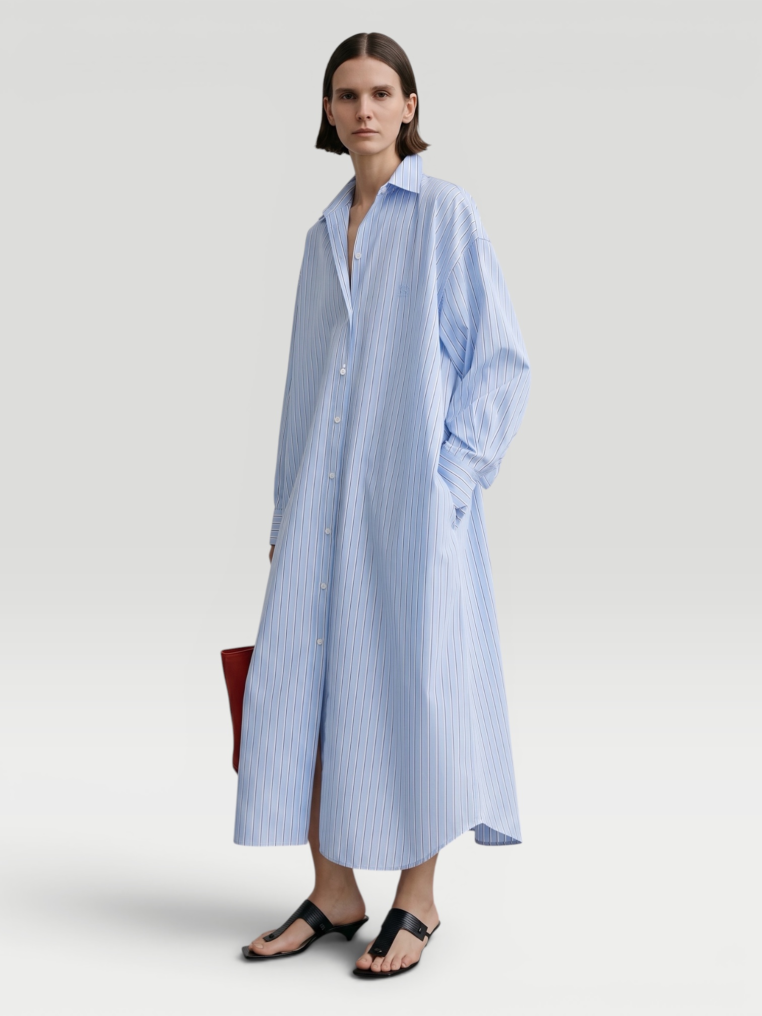 Totême Striped Shirtdress in pale blue / red, worn with Loewe Leather-Trimmed Raffia Tote. Styled by Sharon Lombardo for FDV Concierge.