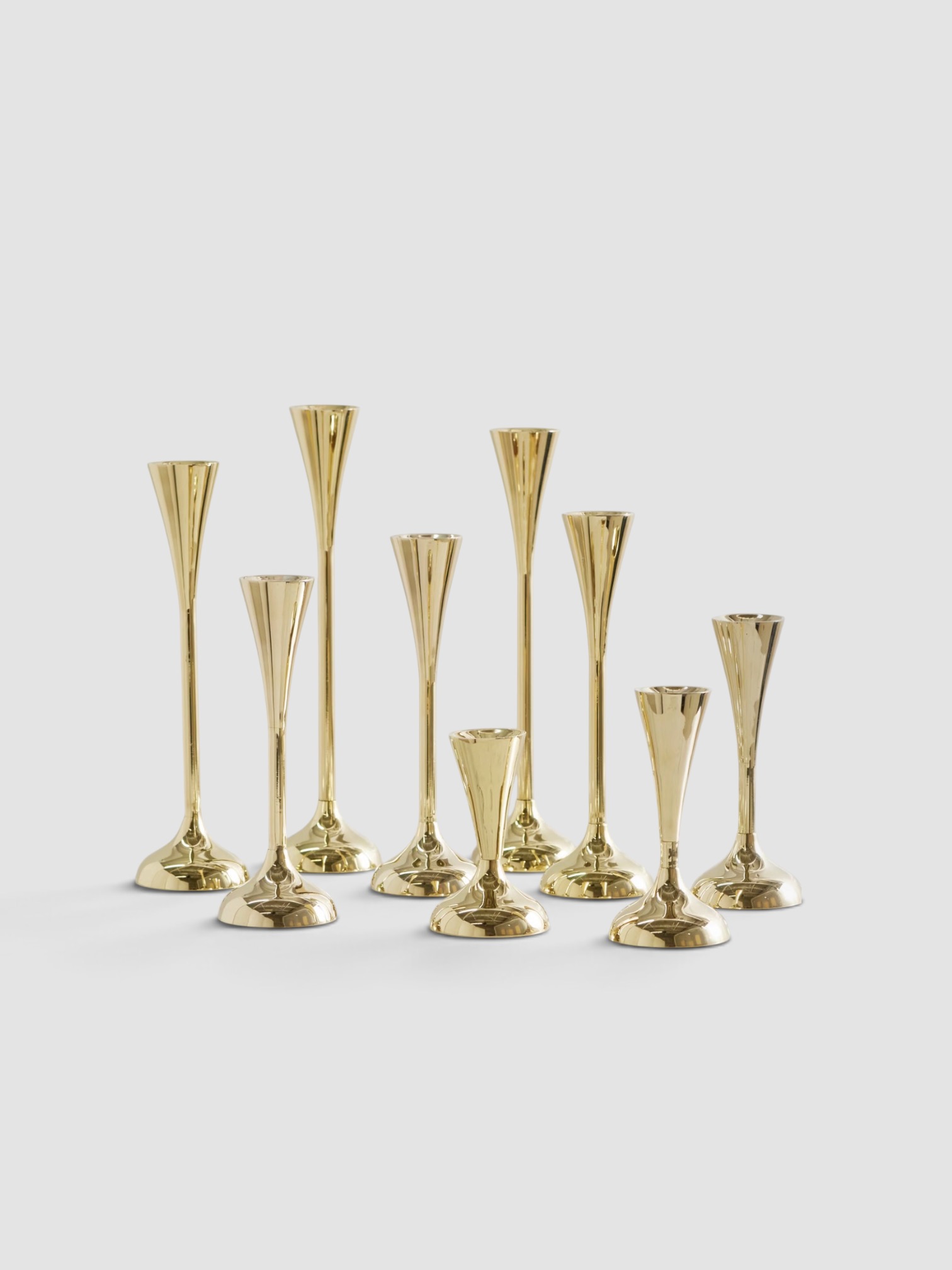 Fourth Street Drip Set of Nine Gold-Tone Candleholders in gold.