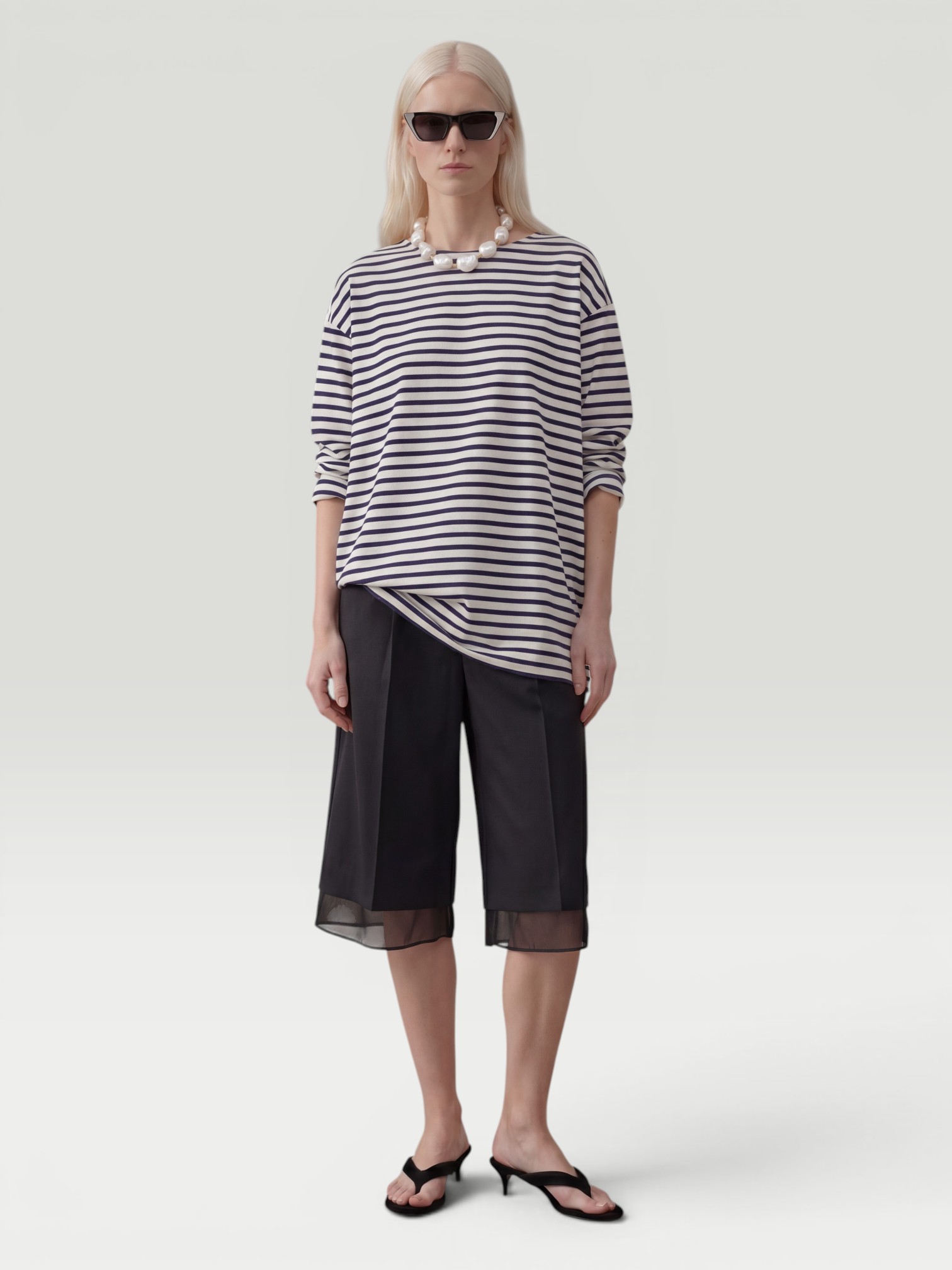 Róhe Organza Lined Shorts in black, worn with Matteau Breton Stripe Tee, Phoebe Philo Peak Sunglasses, Bottega Veneta Pearl Necklace, Alaïa Heel Thong Mules in Velvet. Styled by Sharon Lombardo for FDV Concierge.